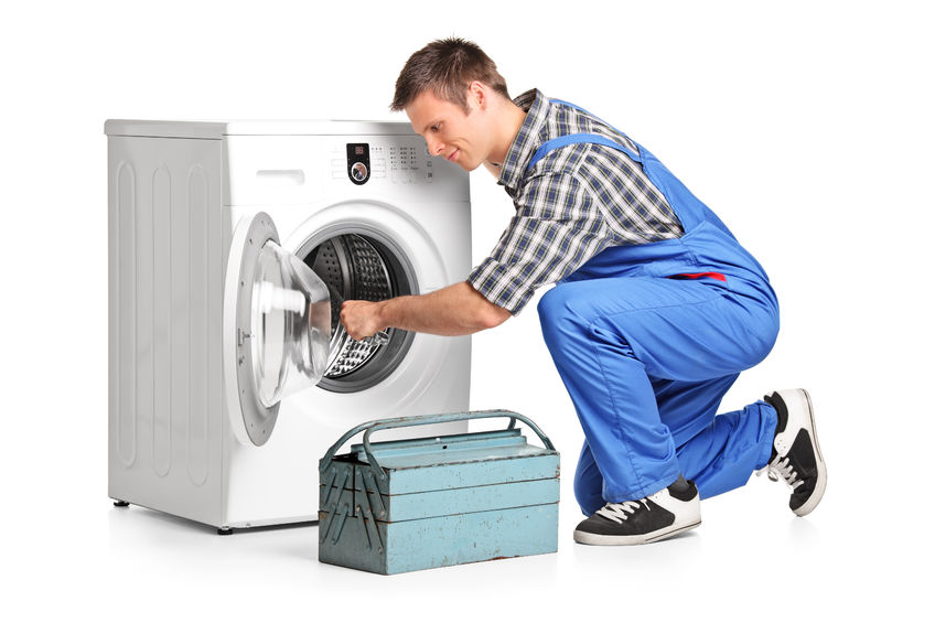 29023337 – young plumber fixing a washing machine isolated on white background